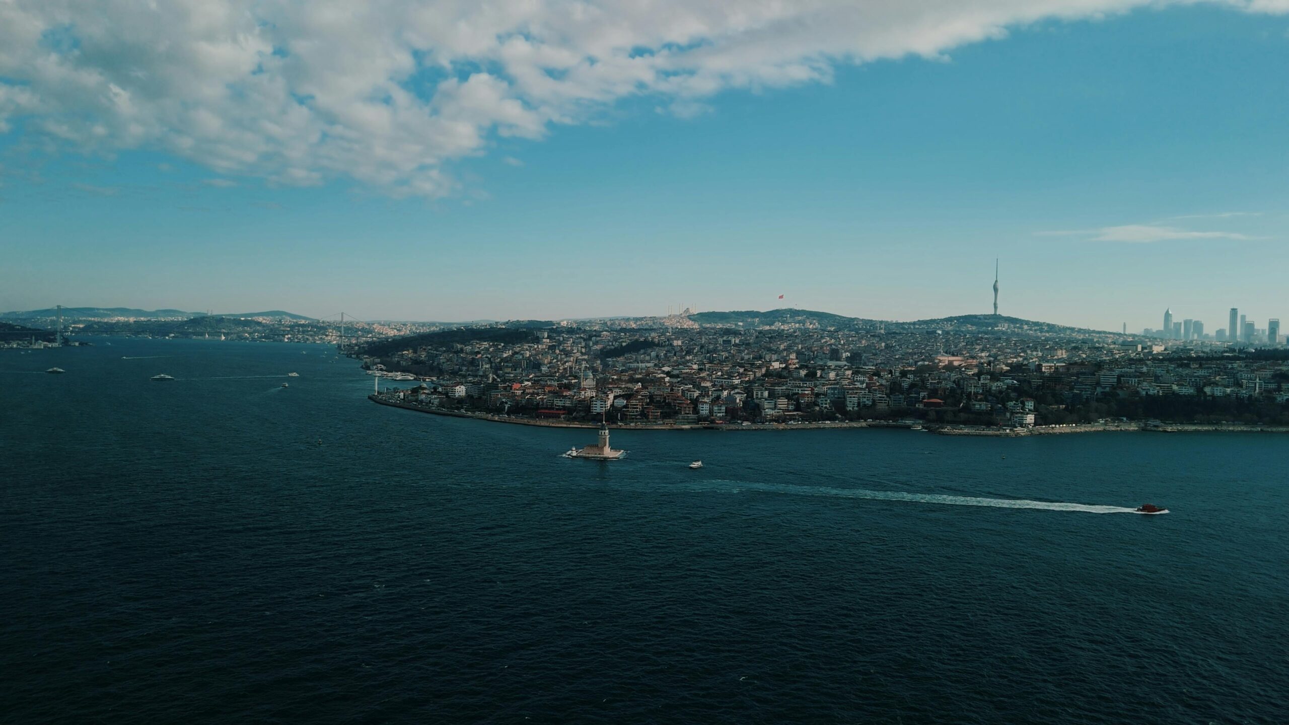 A breathtaking aerial shot of the Maiden's Tower in the Bosphorus, Istanbul, under clear blue skies.